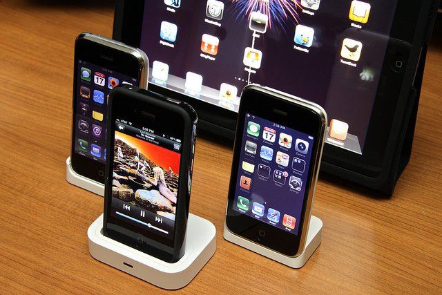 Des iPhone et un iPad disposés sur une table.