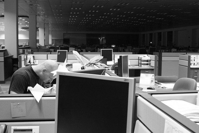 Un homme travaillant à son bureau dans un open space.