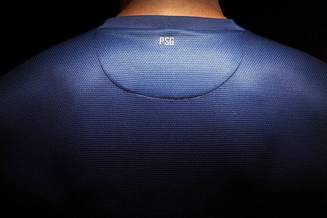 Homme portant le maillot du PSG de dos.